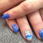 A woman's hands with blue and white nail art.