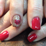 A woman's hands with red and gold nails.