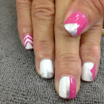 A woman's pink and white nails with chevron designs.