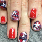 A woman's nails with red, white and blue designs.