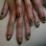 A woman with gold and black nails on a couch.