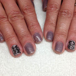 A woman's hands with gray and silver nail polish.