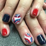 A woman's hands with red, white and blue nail designs.