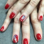 A woman's hands with red and white nail art.