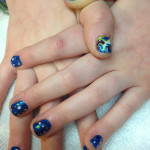 A woman's hand with a blue and green design on it.