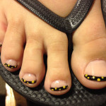 A person's toes with black and yellow polka dots.