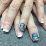 A woman's hand with a blue and white nail design.