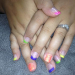 A woman's hands with colorful nails and a ring.