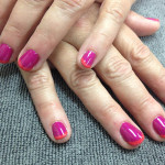 A woman's hands with pink and orange nails.