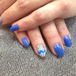 A woman's hands with blue and white nails.