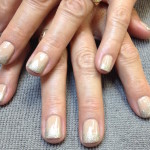 A woman's hands with beige and silver nails.