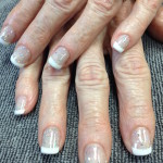 A woman's hands with white and silver nails.