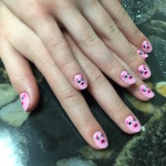 A woman's hands with pink nail art on them.