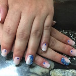 A woman's hands with blue and white nail art.