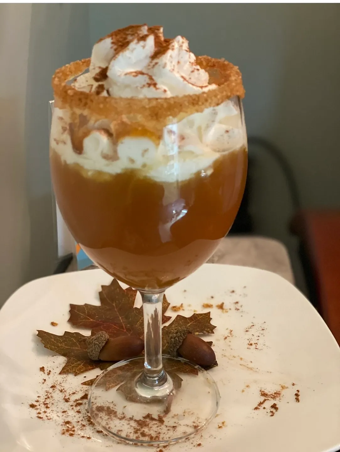A glass of chocolate drink with whipped cream and caramel.