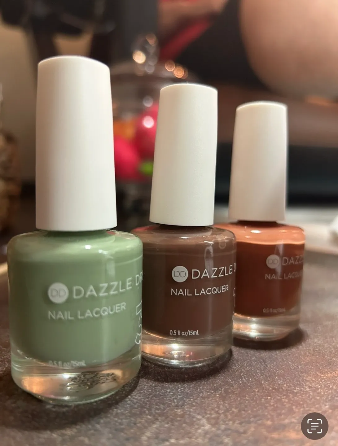 Three different nail polish bottles sitting on a table.
