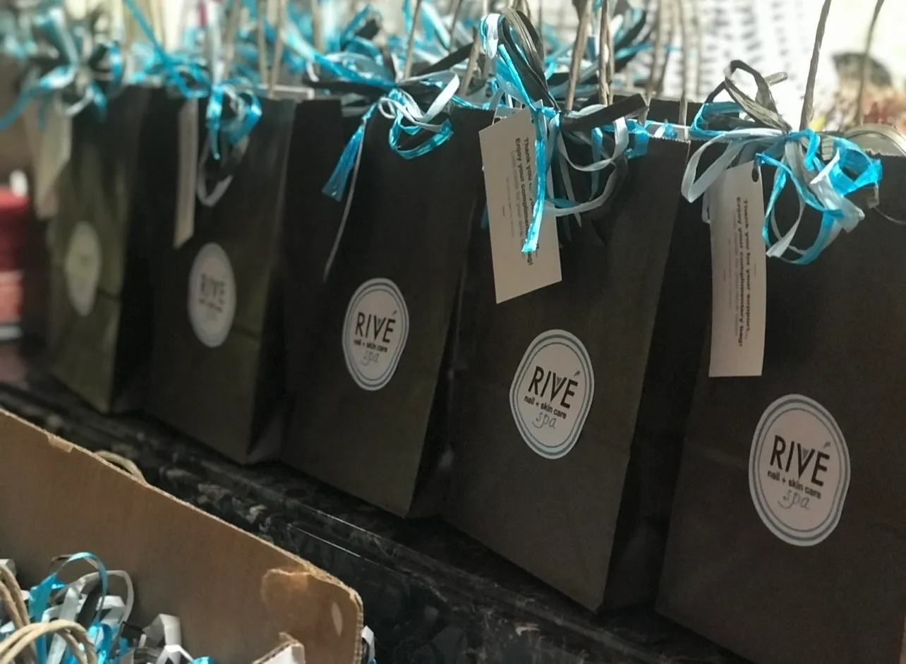A row of bags with blue ribbons on them.