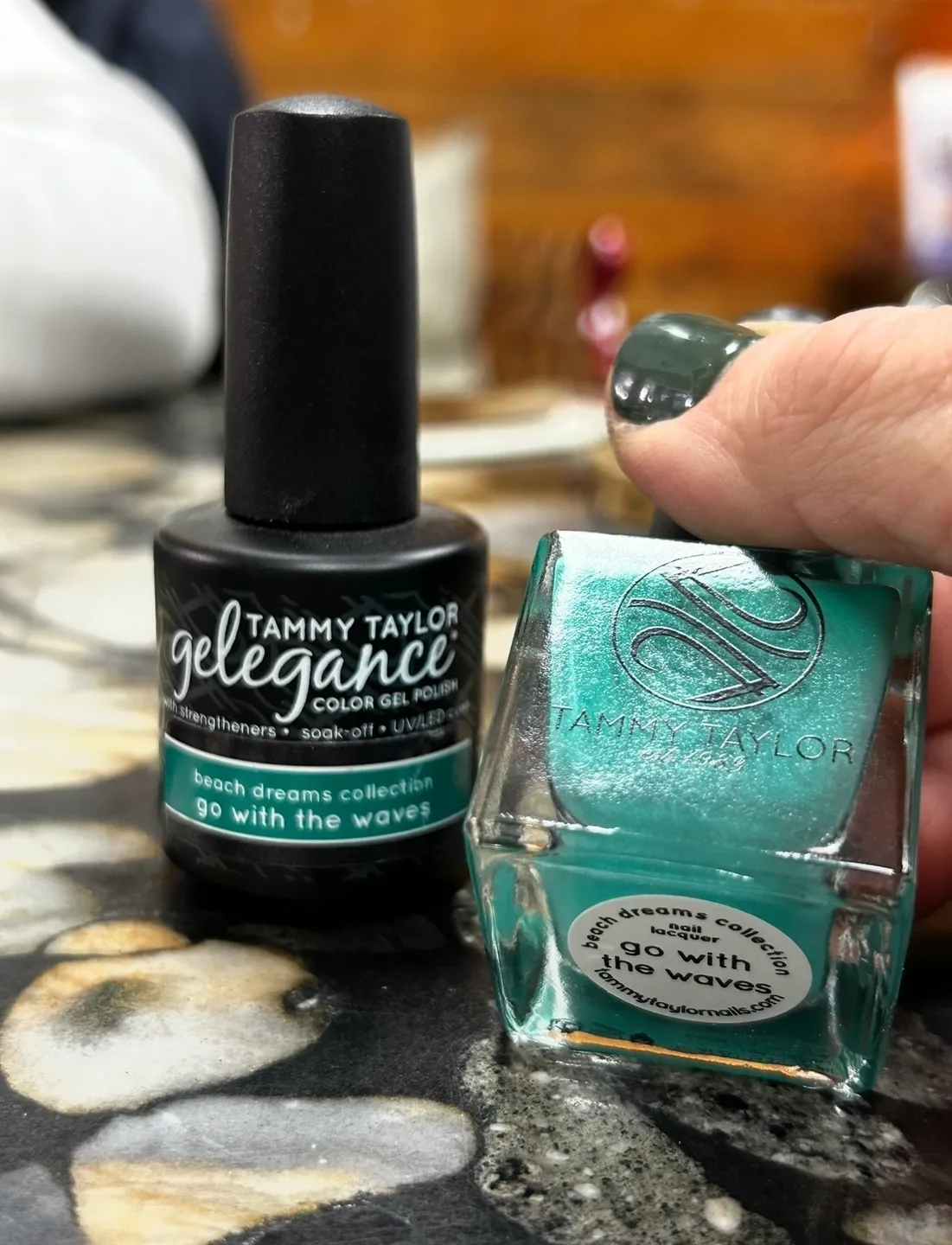 A person is putting some green nail polish on