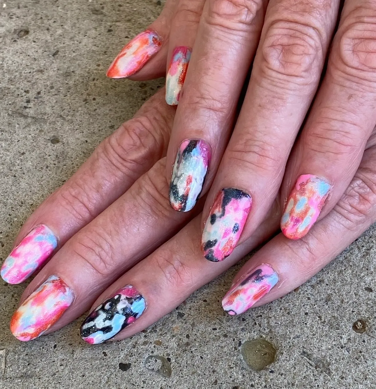 A woman 's nails with different designs on them.