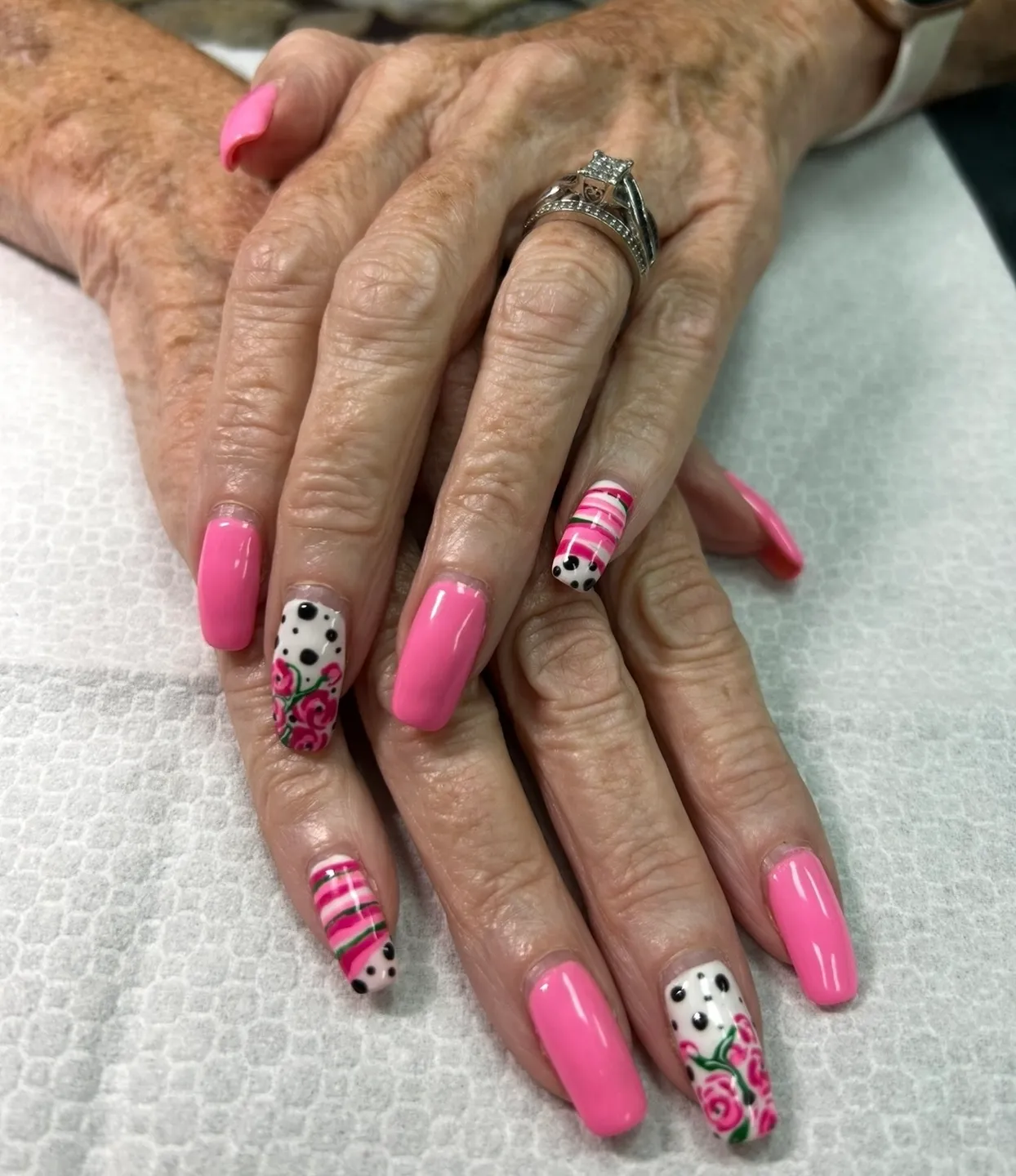 A woman with pink and white nail art on her nails.