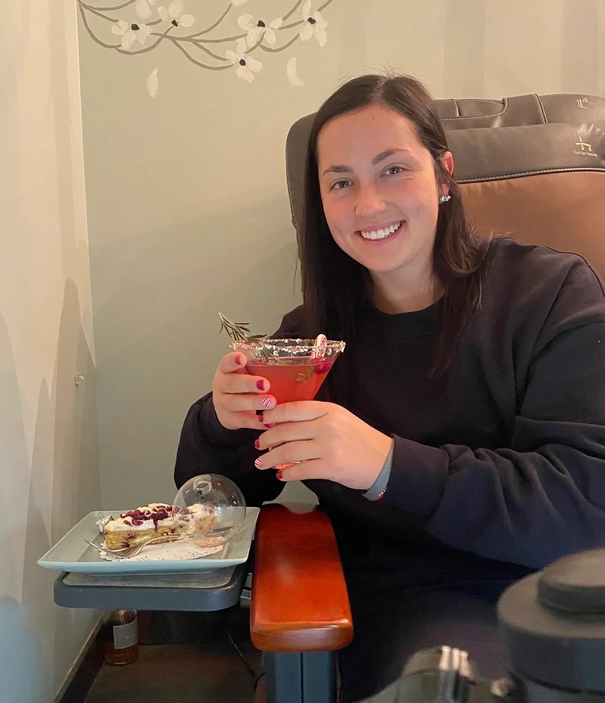 A woman sitting in front of some food and drinks.