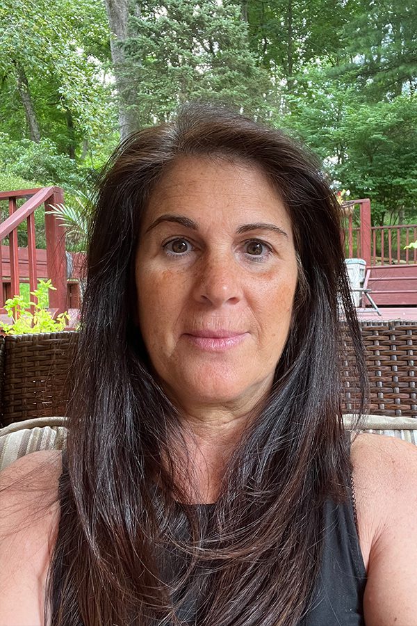 A woman with long hair sitting on top of a chair.