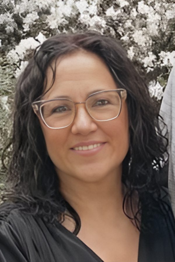 A woman with glasses smiling for the camera.